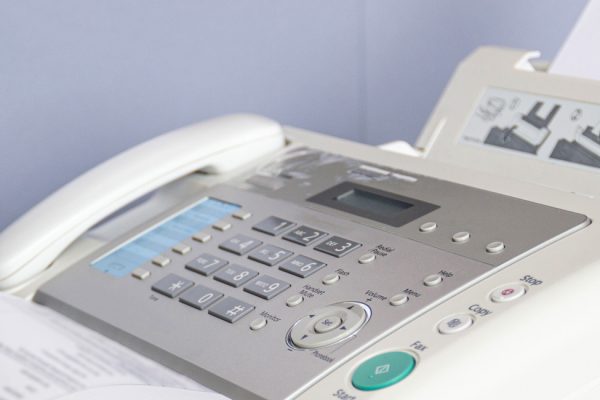 hand man are using a fax machine in the office